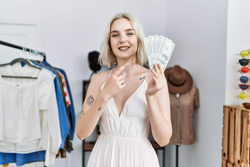 5 Passive Income Ideas for Small Business Owners in 2025: Boost Your Revenue with Ease 8 Boutique owner with check showing best passive income for small business 2025 benefits.