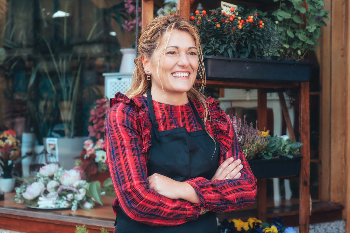 Small biz owner smiling at laptop with passive biz income 2025 ideas.